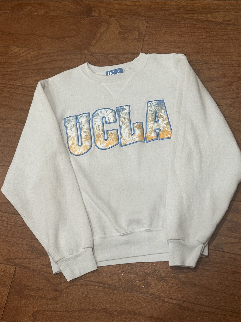 Gold Standard UCLA White Crewneck Sweatshirt with Blue and Gold floral Lettering